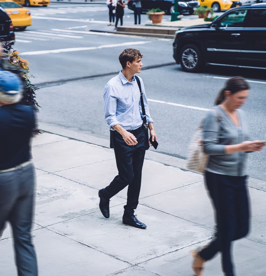 Confident businessman holding bag walking on street
