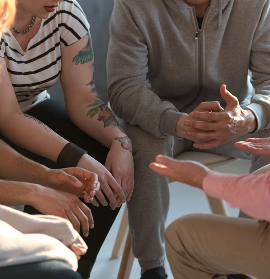 Rebellious youth with tattoos talking about problems during meeting with therapist