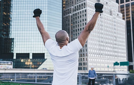 Ethnic sportsman with hands up on street